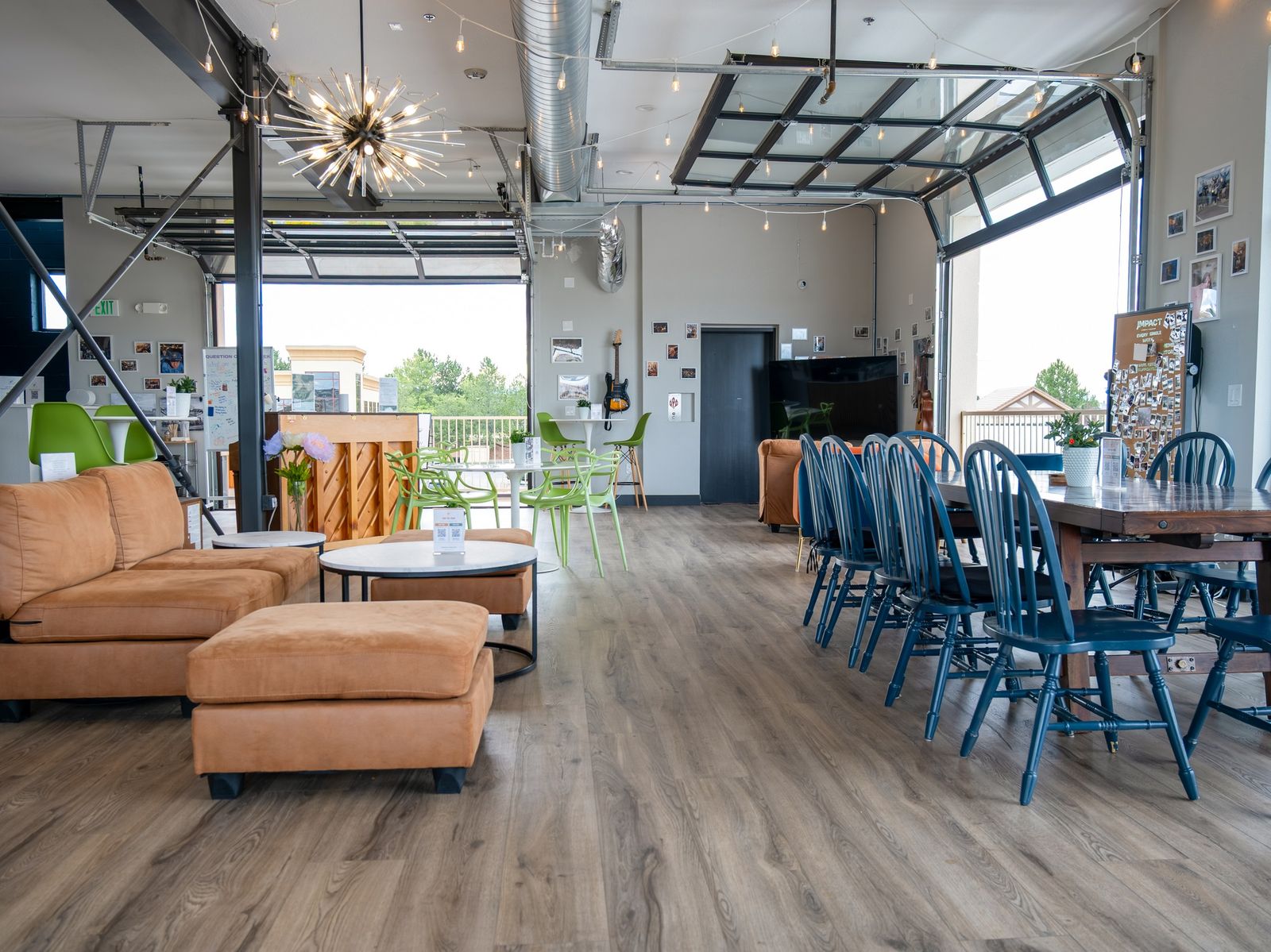 The room upstairs at Happy Crew Coffee House: sofas, a long table and big windows